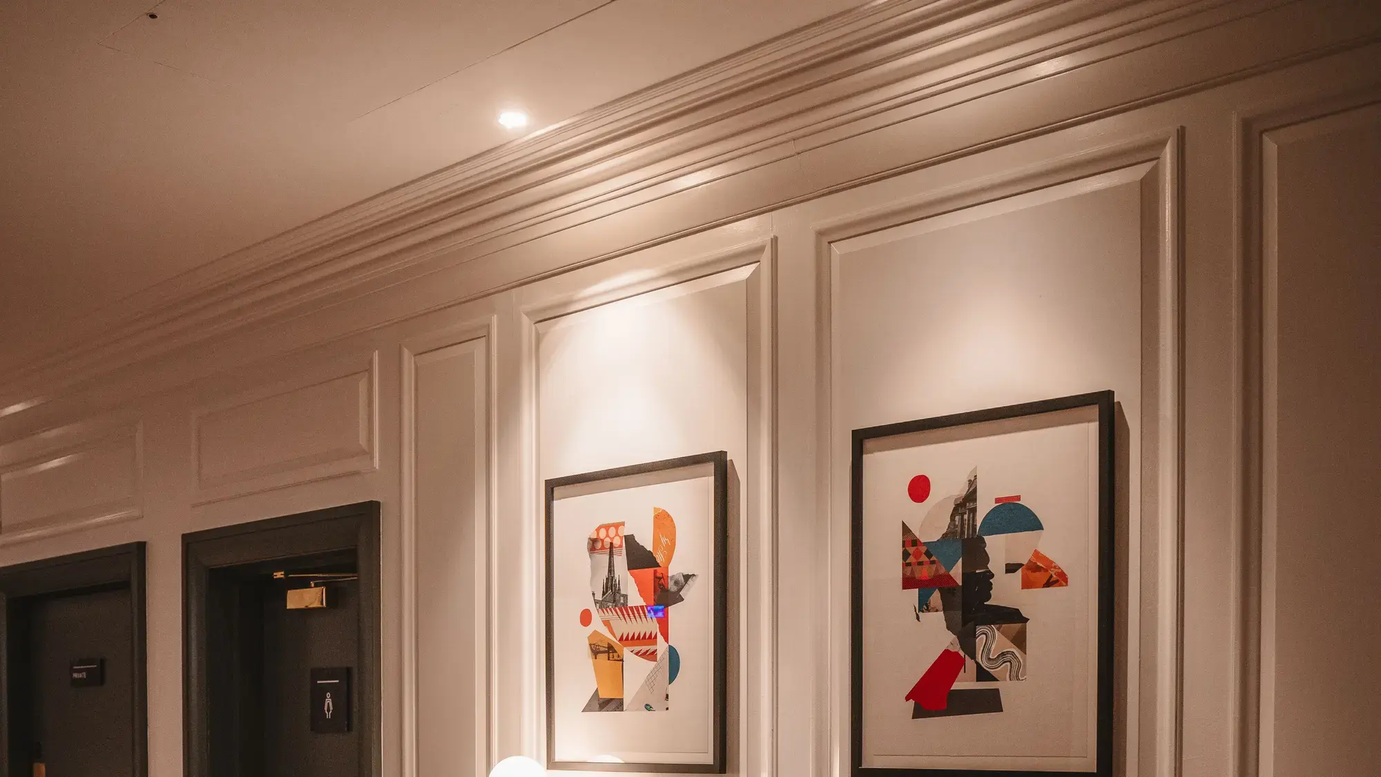 Lobby contemporâneo de hotel boutique com arte emoldurada curada